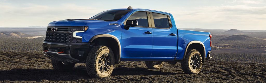 Blue 2026 Chevrolet Silverado ZR2 parked on a hillside with rugged tires.