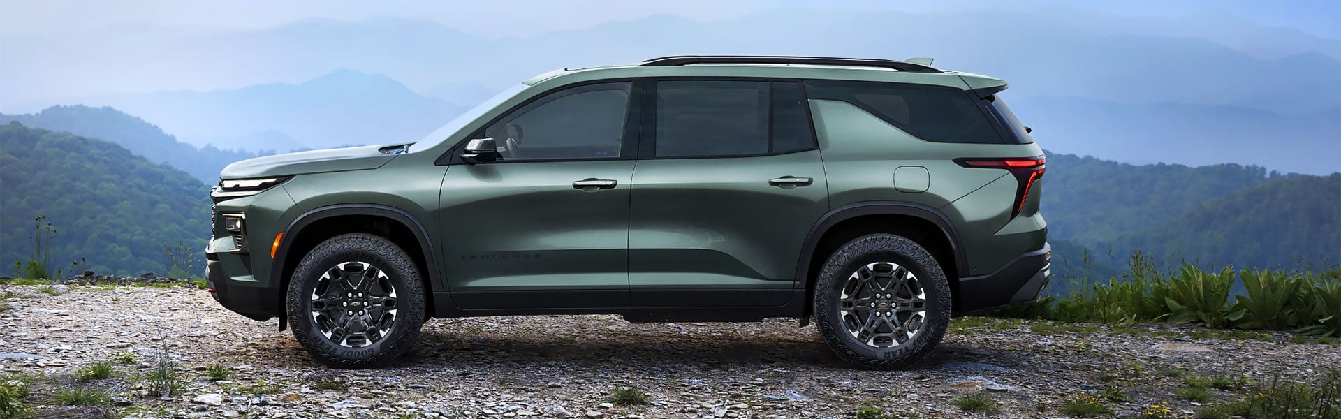 Green Chevrolet Traverse SUV in a mountain setting.